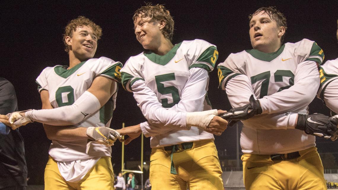 Borah’s Ellis Magnuson, left, quarterback Jake Standlee and Joe Metzger sing the school fight song after Borah beat rival Capital 42-27 in the first round of the 5A football state playoffs on Friday at Dona Larsen Park.