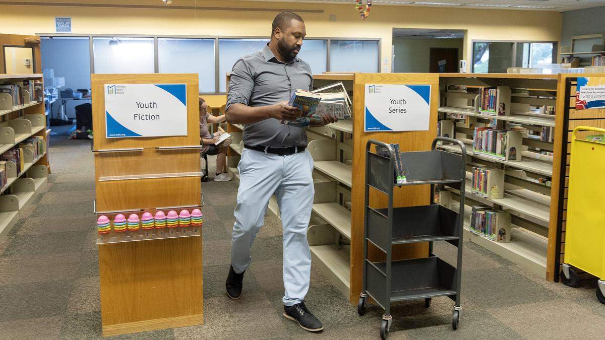 Meridian Library District Director Nick Grove works to organize books as they're taken off the shelves at the Meridian Library District Cherry Lane branch for renovations to the building, Aug. 14, 2025.
