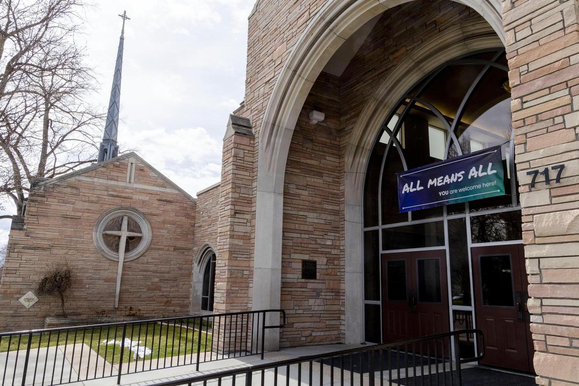 A banner reading “All Means All: YOU are welcome here!” hangs above the entrance to Cathedral of the Rockies on March 31.