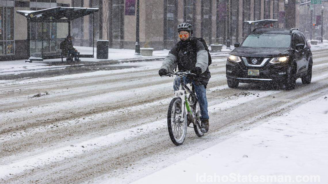 A man rides his bike during a snowstorm in downtown Boise. Boise saw its coldest temperatures Saturday morning in at least four years.