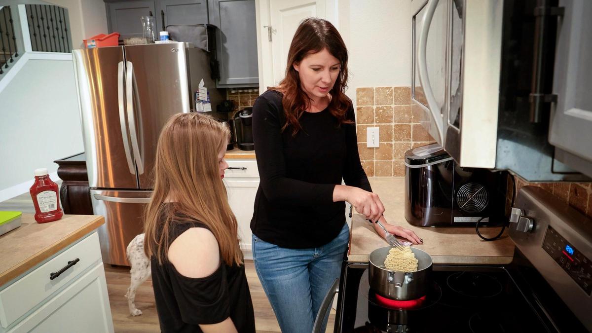 Shannon French helps her daughter, Ruby, make lunch. Under the oversight of Idaho’s Department of Health and Welfare, Medicaid has paid for French to care for Ruby, who has Down’s Syndrome, and her brother, who has autism. But amid ballooning program costs, the department is shuttered the program July 15.