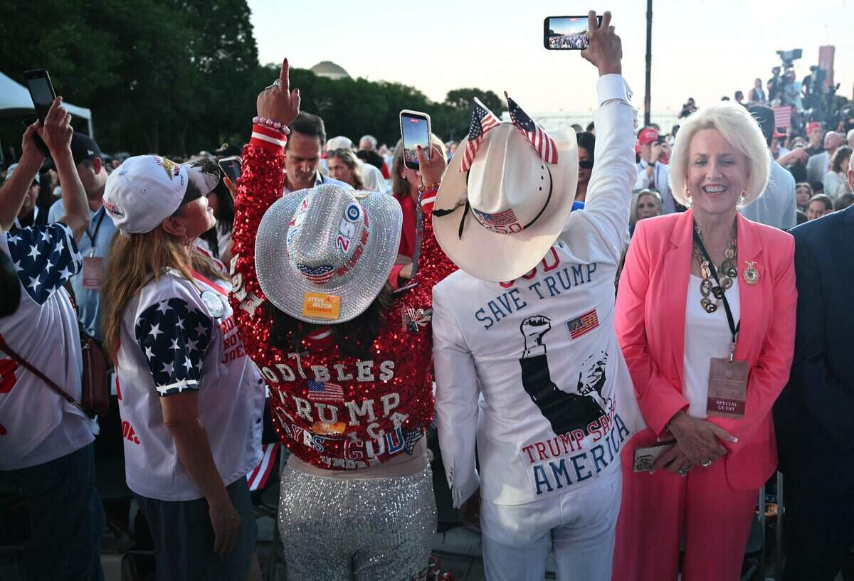 Attendees take pictures as they await the arrival of US President Donald Trump during a kick-off celebration for the "Great American State Fair" on the National Mall in Washington, DC, on June 24, 2026. The "Great American State Fair" will be held from June 25 to July 10, 2026, to celebrate the 250th anniversary of US independence. (Photo by Mandel NGAN / AFP via Getty Images)