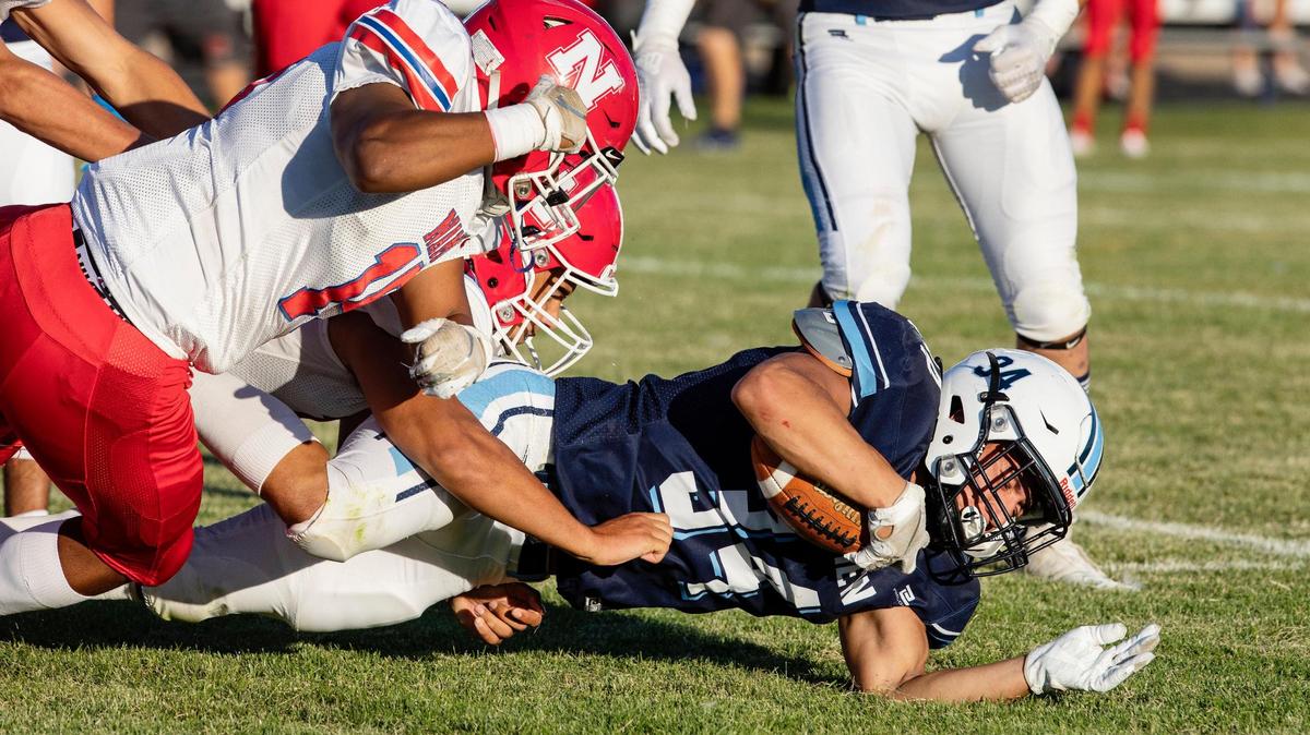 Skyview’s Antonio Fifta is brought down by Nampa’s Joe Anguiano and two other defenders during their football game Friday at Skyview High School. The Hawks won 21-0.