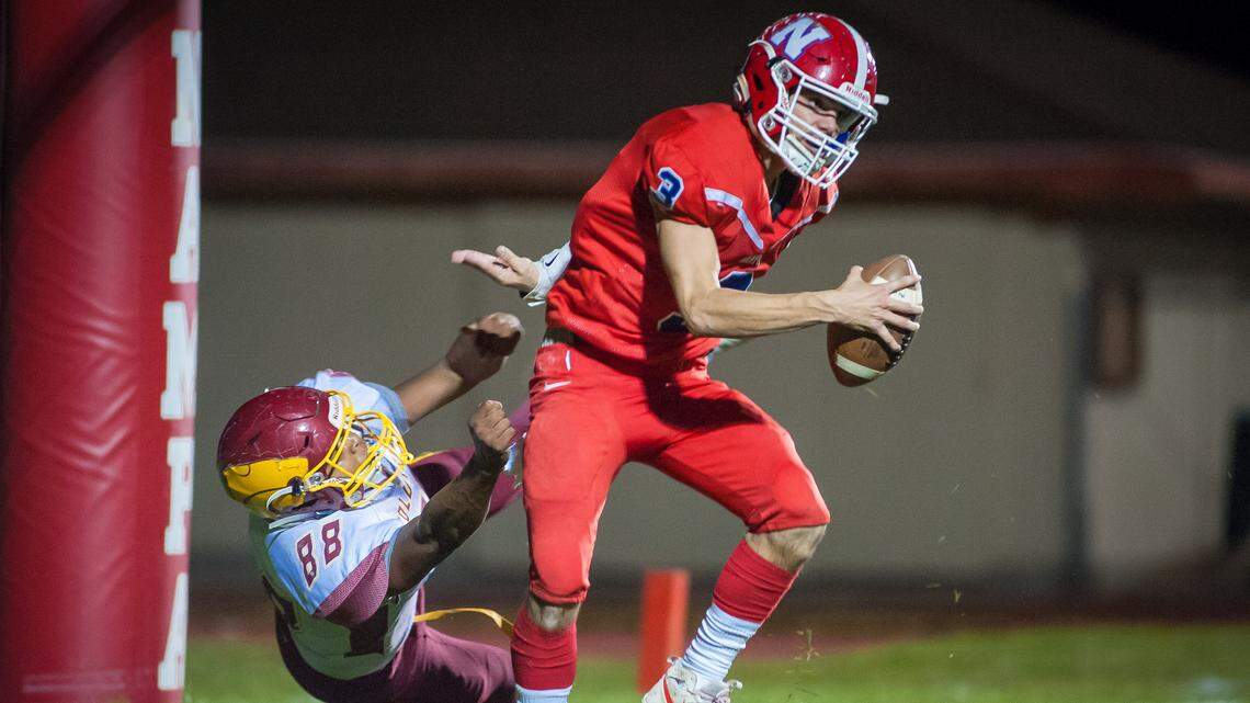 Nampa quarterback Braden Minor narrowly escapes a safety at the hands of Columbia’s Michael Cox during Nampa’s 40-19 win Friday in the 4A state quarterfinals.