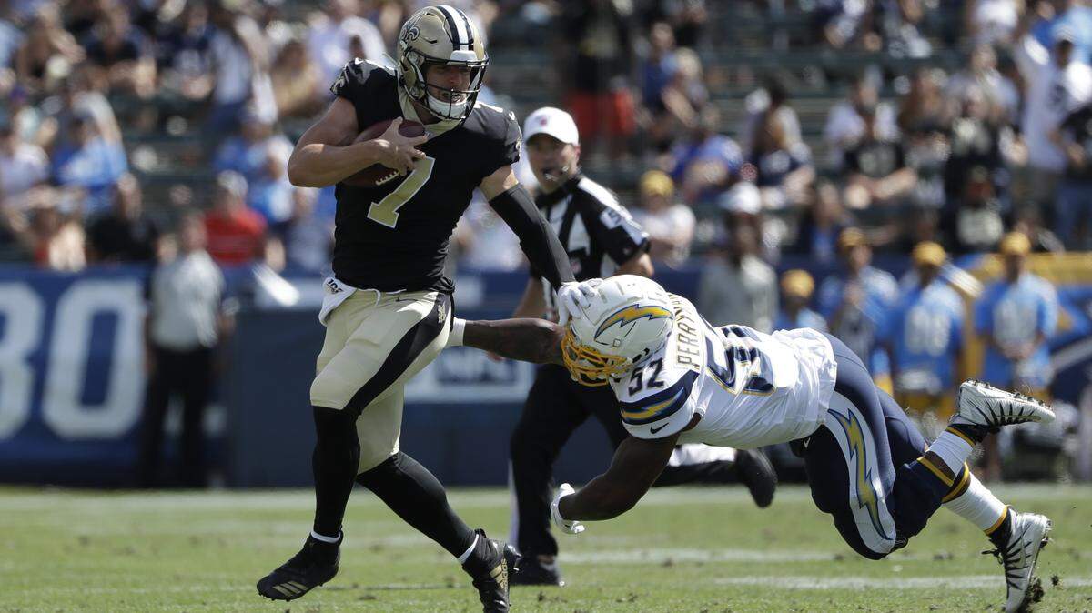 New Orleans quarterback Taysom Hill stiff arms a defender to the turf during a preseason game Sunday. The Pocatello native turned in his best performance under center yet,  rallying the Saints to a 19-17 win over the Los Angeles Chargers.