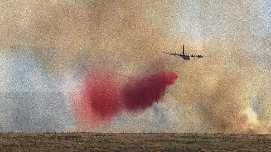 An airplane drops fire retardant on a vegetation fire east of Blacks Creek Road in this June file photo.