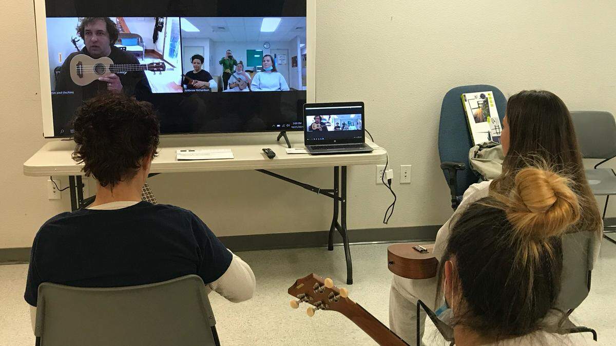Instructor Thomas Paul, on screen, teaches ukulele to Crysti Belanger, Victoria Augerlavoie and Emily Dunham as part of the Idaho Prison Arts Collective.