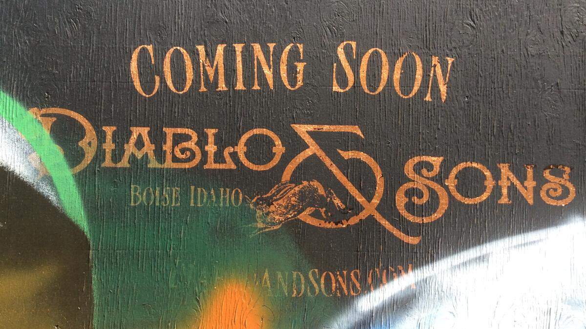 The spray-painted construction wall outside Diablo & Sons promises that the new bar and restaurant is “Coming Soon.”