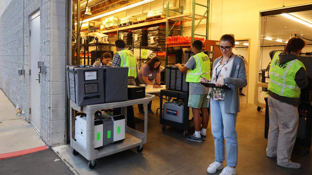 Workers check which of the county’s precincts have dropped off their ballots.