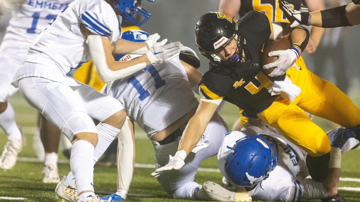Bishop Kelly senior running back Peter Minnaert, right, fights for extra yards in the first quarter of a 4A state quarterfinal against Emmett on Friday. Minnaert ran for 175 yards and two touchdowns to lead the Knights to a 28-7 win.