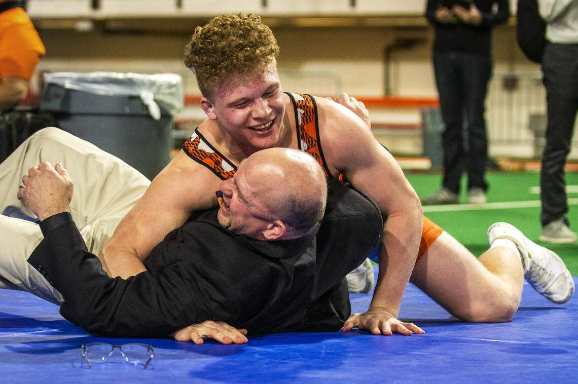 Fruitland senior Jonathon Fagen throws his father, John Fagen, to the mat as he celebrates his victory Saturday, Feb. 23, 2019, during the State Wrestling Championships at Holt Arena in Pocatello. Fagen pinned Bonners Ferry senior Gabe See at 1:44 to claim the 3A 195-pound state title, his fourth consecutive state title.