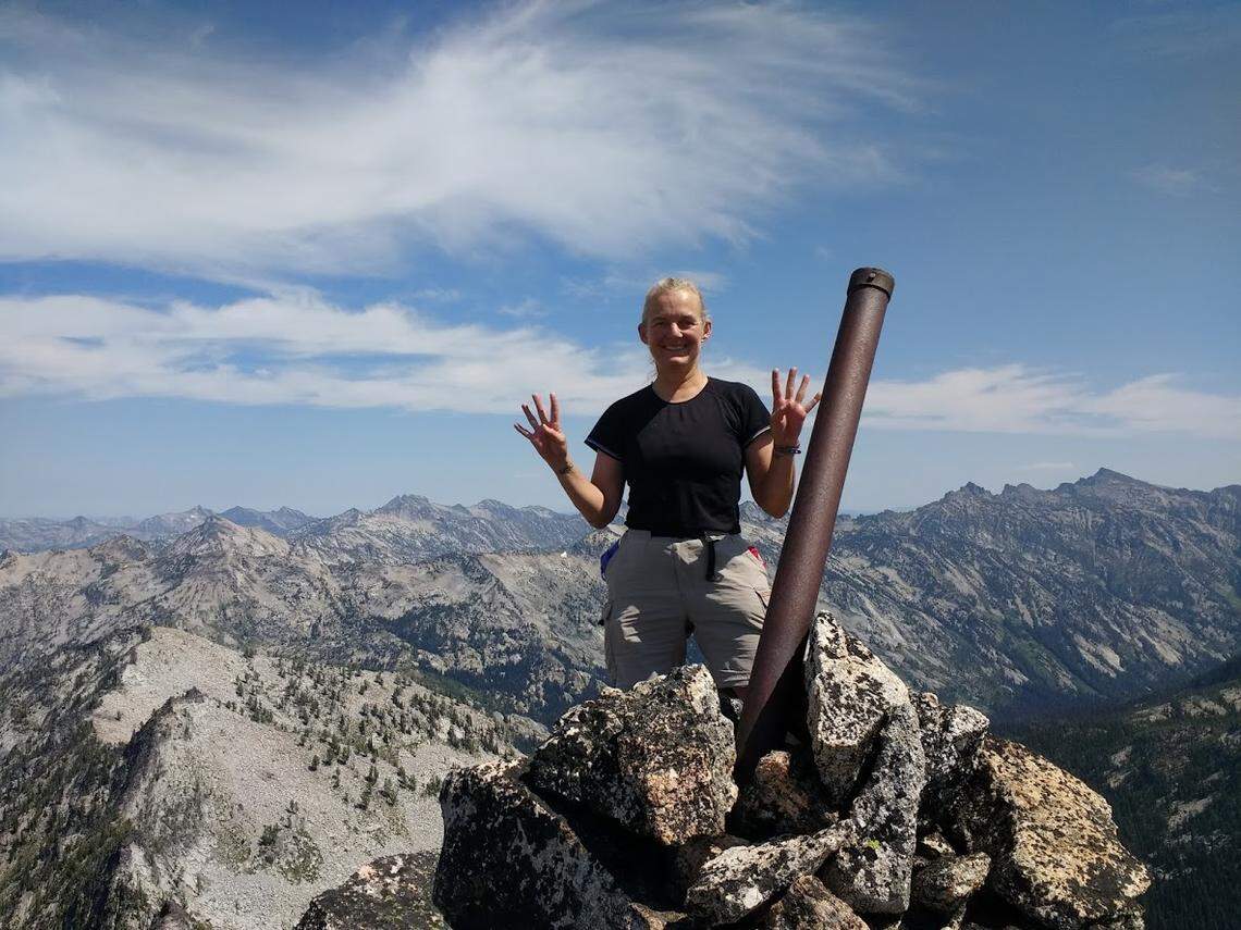 Terri Rowe, of Meridian, stands on top of Bare Peak NW in Idaho County on Aug. 6, 2019, while holding up four fingers on each hand to symbolize Idaho’s 44 counties. Rowe became the first woman and only the eighth person to ever reach the highpoint of each of Idaho’s counties when she summited Bare Peak.