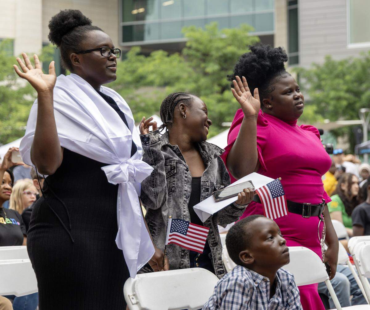 People take their oath of citizenship to become United States citizens during a celebration of World Refugee Day in 2023.