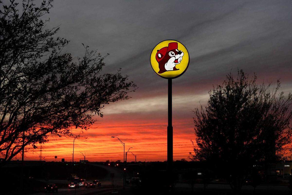A Buc-ee’s sign, with its iconic beaver mascot, stretches up above the horizon in Terrell, Texas.