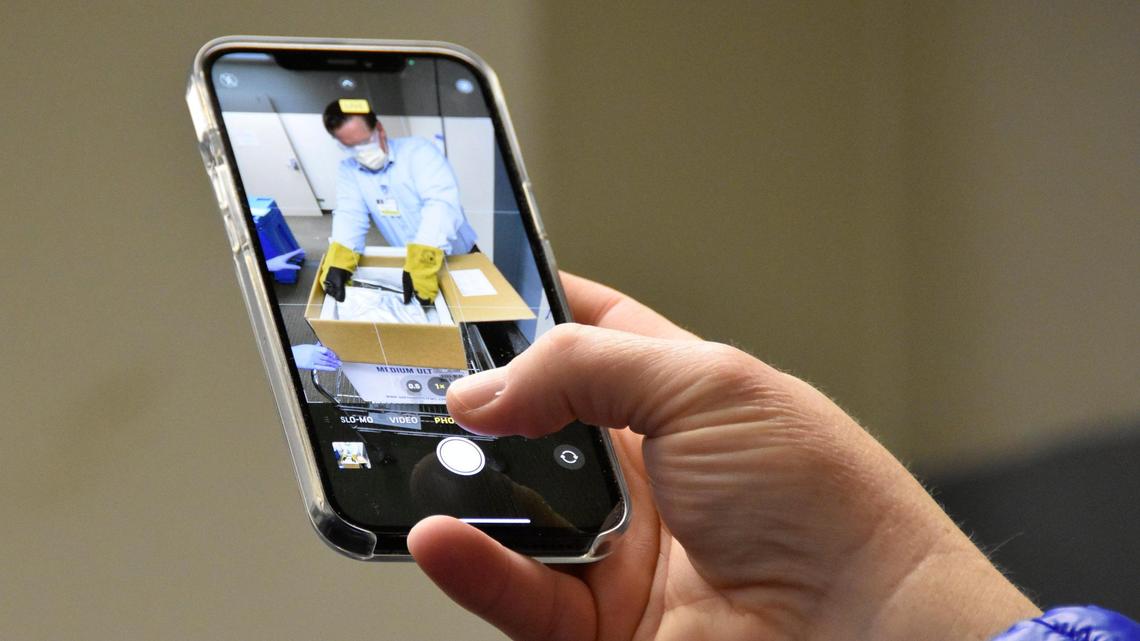 “A historic moment,” says an observer as Scott Milner, St. Luke’s senior director of pharmacy, opens special box that keeps the coronavirus vaccine at the proper sub-zero temperature.