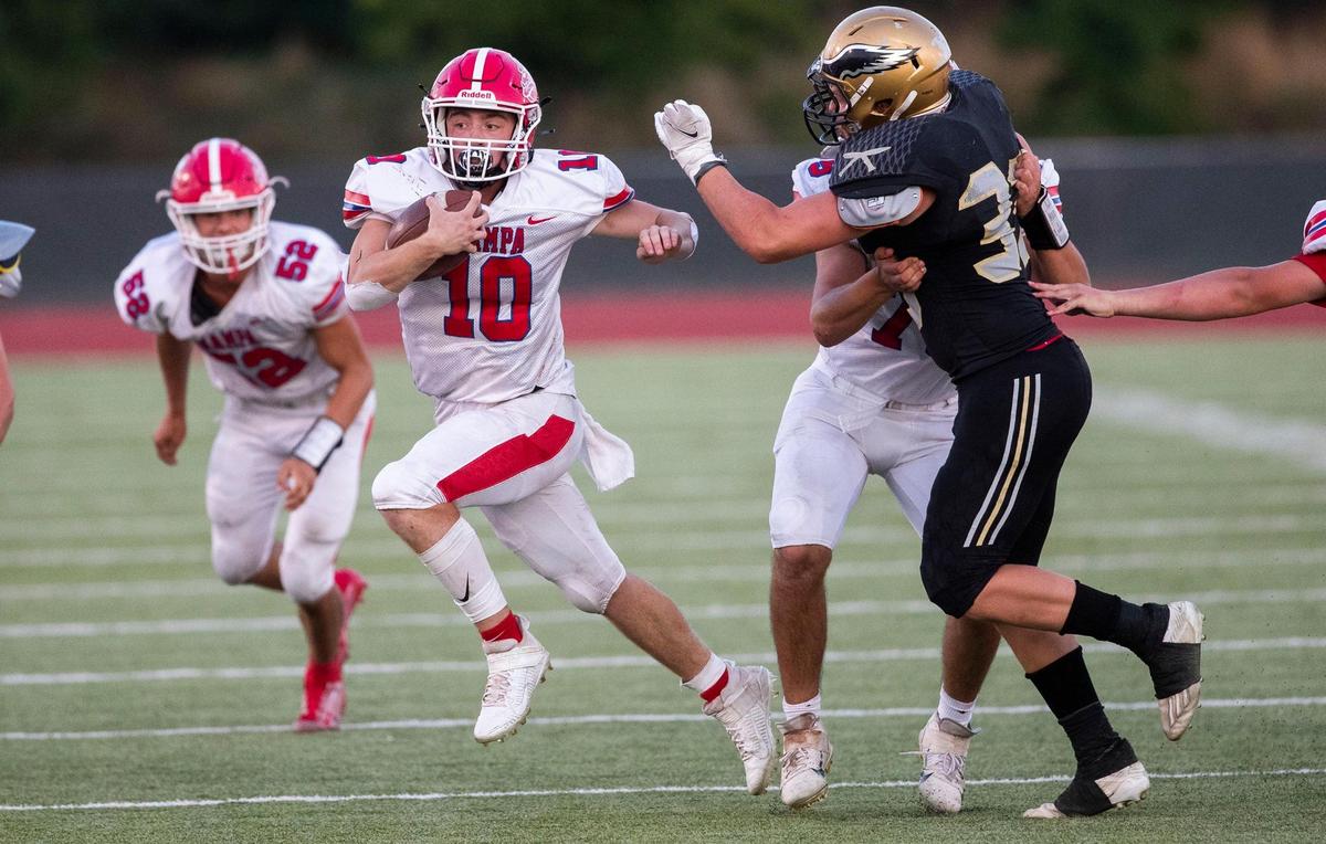 Nampa running back Ryan Schuler follows a block from lineman Alexander Daniluc on Aug. 26 at Dona Larsen Park.