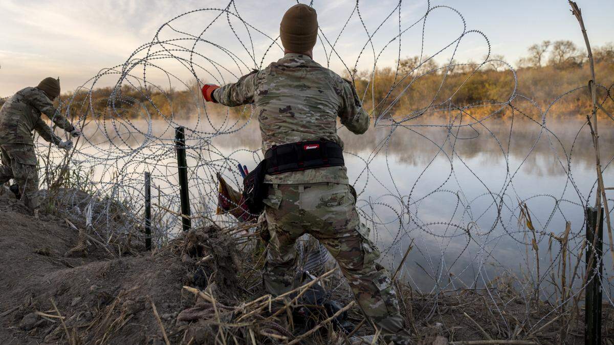 Texas National Guard soldiers install additional razor wire lie along the Rio Grande on January 10, 2024, in Eagle Pass, Texas.