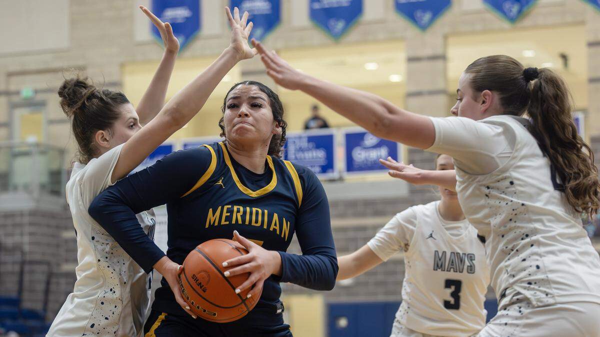 Meridian sophomore McKinnley Puello controls the ball as Mountain View players play defense during their 6A District Three girls basketball tournament play-in game, Tuesday, Feb. 3, 2026.