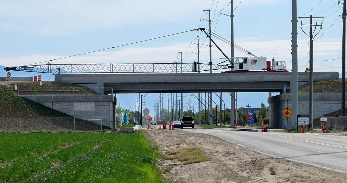 A construction crane slowly moves over McMillan Road where one of many overpasses have been built to expand Idaho 16 south to Interstate 84.
