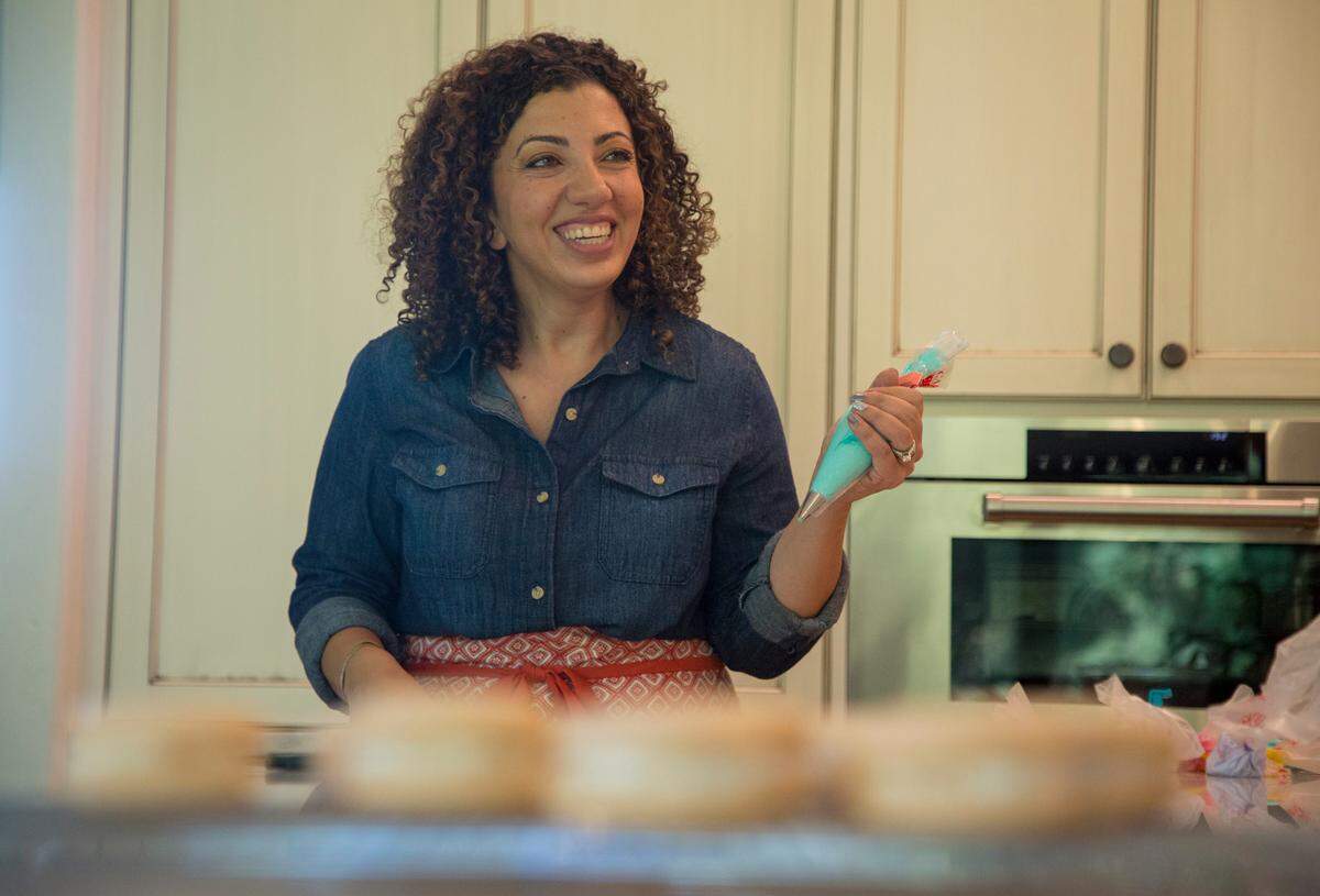 Rose Gebran of RoRo’s Cookies decorates sugar cookies with homemade frosting in her Eagle home.