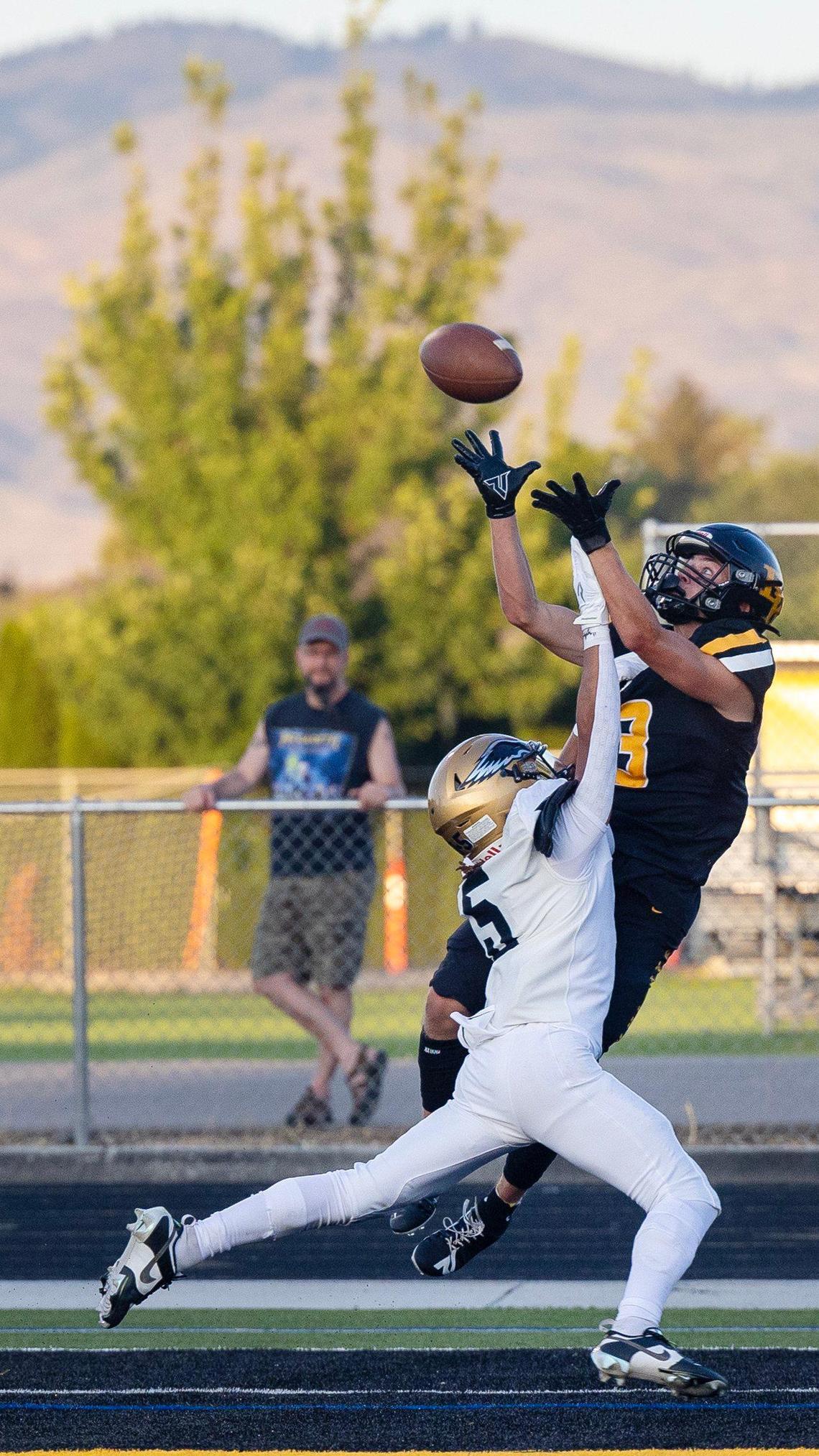 Bishop Kelly senior Cooper Cammann leaps for a touchdown grab over Capital’s Marcellus Clay in the second quarter Friday.