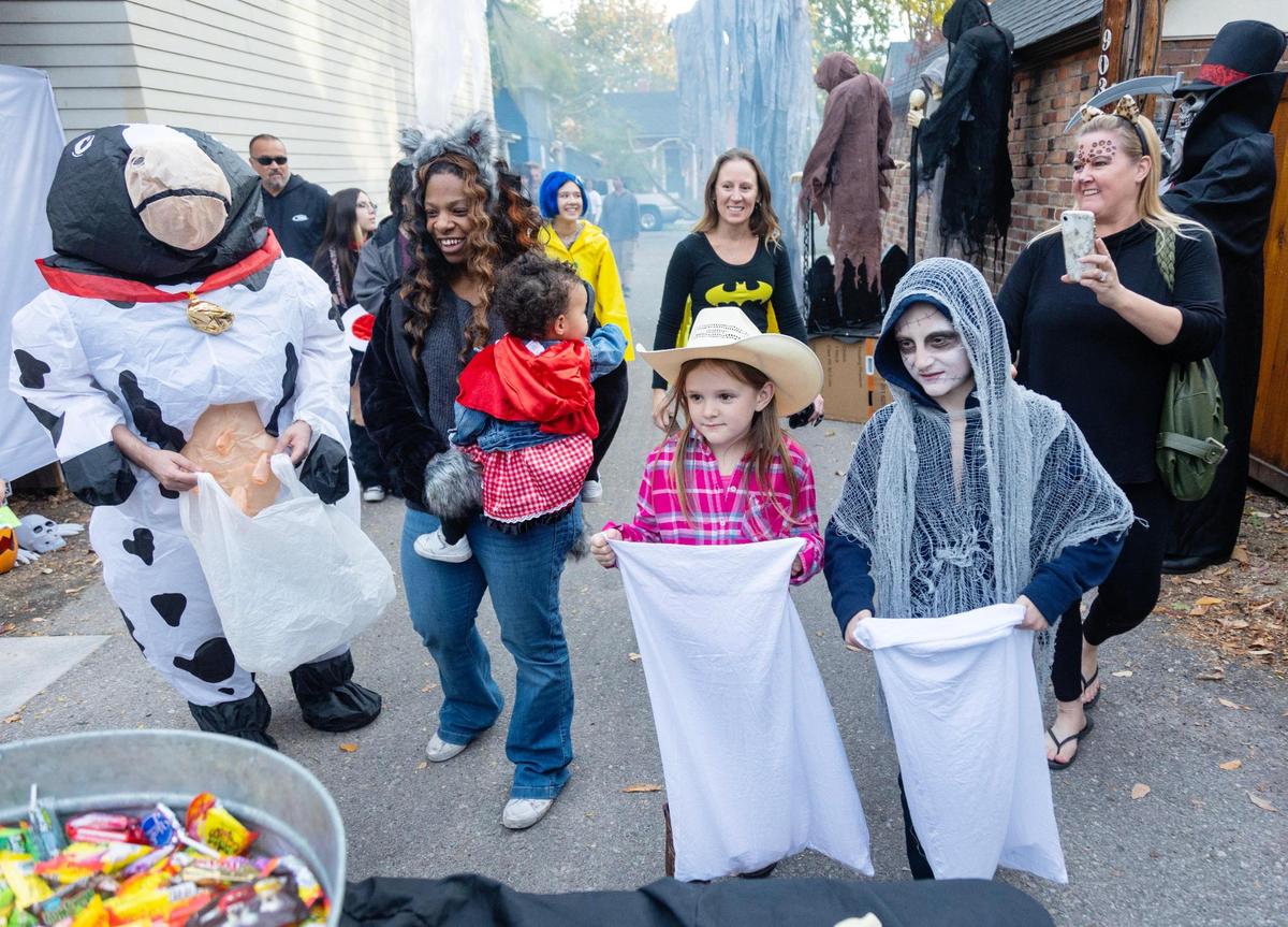 People trick-or-treating walk through Spook Alley behind homes on Harrison Boulevard in Boise during Halloween on Oct 31, 2022.