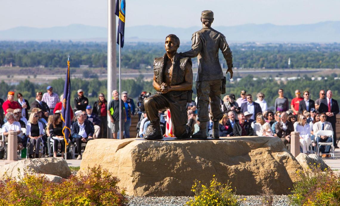 People listen to speakers during a Memorial Day observance event at the Idaho Veterans Cemetery where a statue was unveiled May 29, 2021. The statue, by Idaho artist Benjamin Victor, depicts two U.S. armed forces service members in postures of reverence.