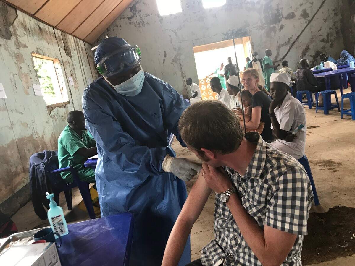 A doctor receives an Ebola vaccine from a health care worker at Congolese treatment center in Nyankunde.