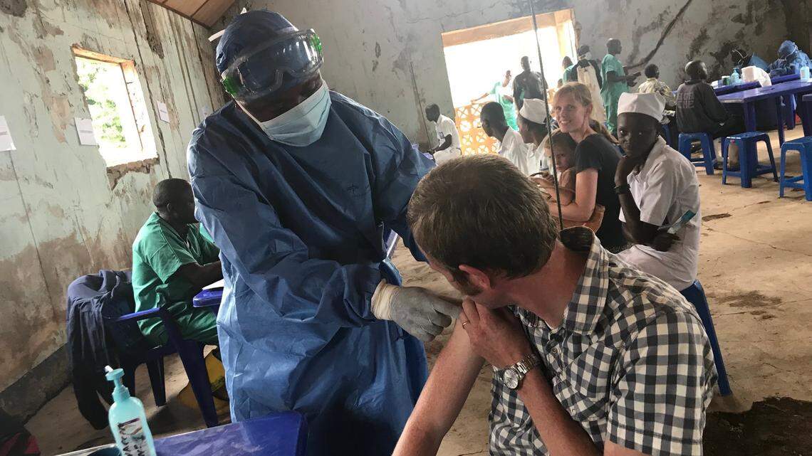 A doctor receives an Ebola vaccine from a health care worker at Congolese treatment center in Nyankunde.