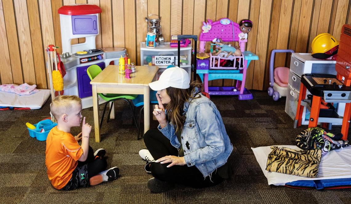 Baylee Johnson, a teacher at Ten Mile Church Daycare, reads to a child.