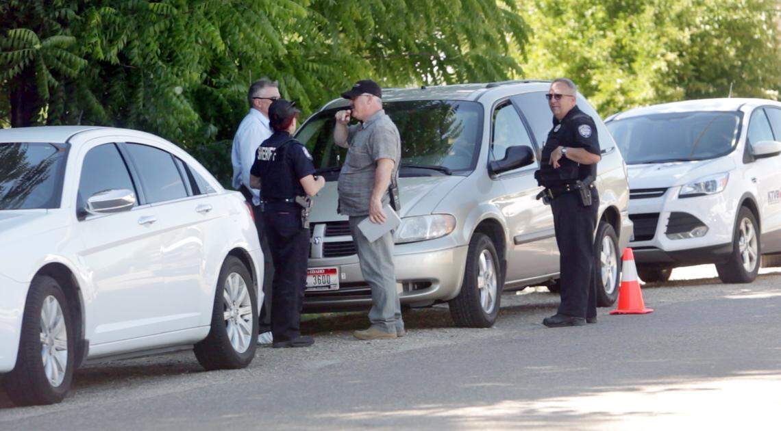 Law enforcement officials investigate the scene at 216 KCID Road where three bodies were found on Tuesday, June 20, 2017. The house is hidden behind the trees.
