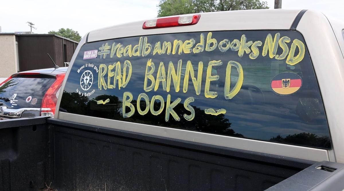 “Read banned books” is written in paint on the window of a truck in the parking lot of the Nampa School District office during a school board meeting on June 16, 2022.