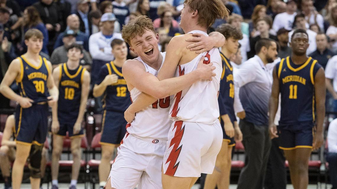 Owyhee juniors Barrett Fernandez, left, and Preston Sherburne embrace after beating Meridian 53-50 in double overtime in the 5A boys basketball state tournament semifinals Friday at the Ford Idaho Center in Nampa.