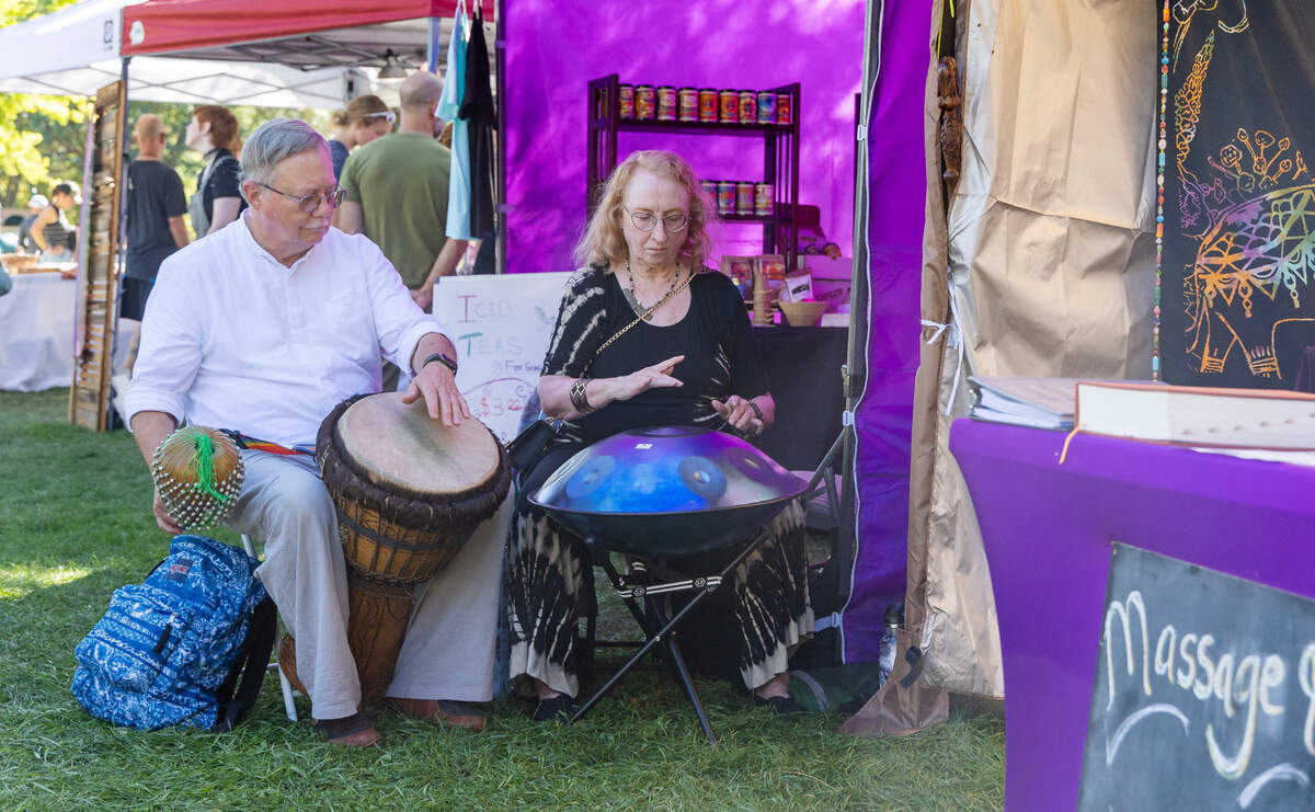 People drum outside of a vendor booth during the Hyde Park Street Fair in 2023.