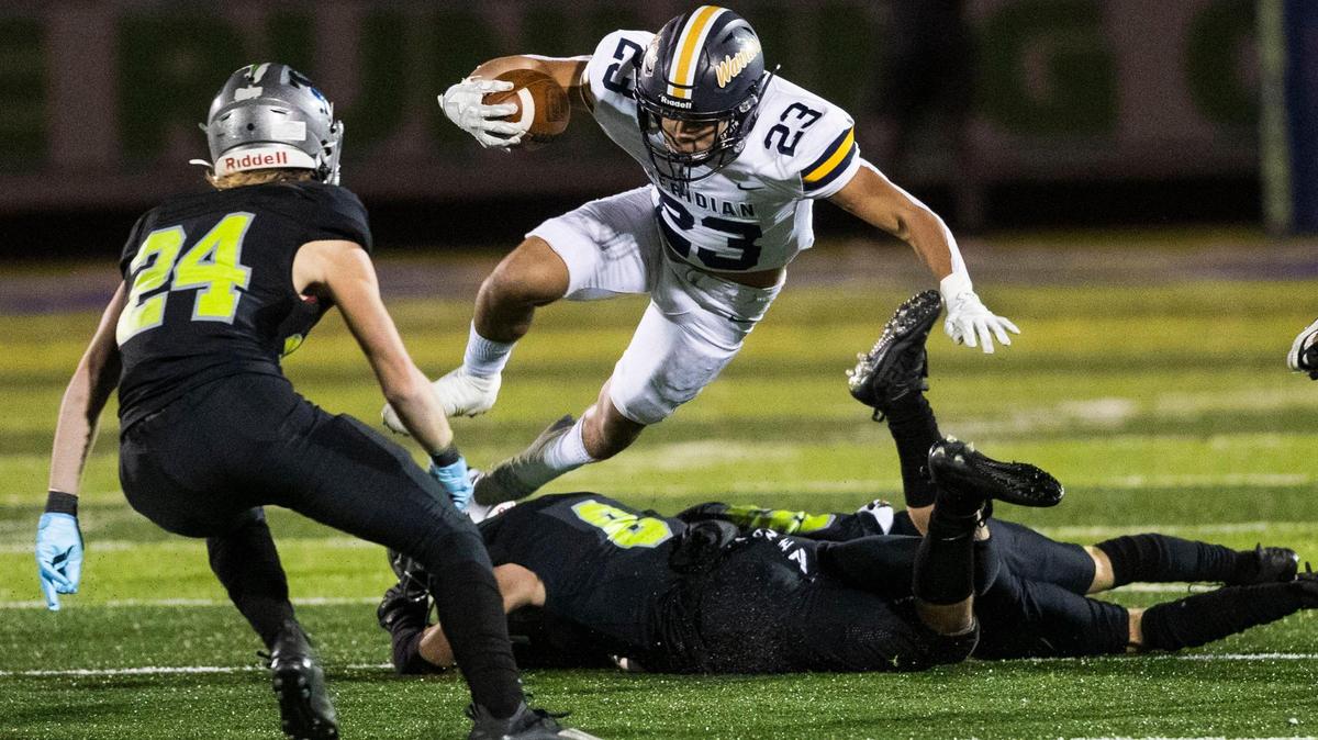 Meridian running back Marco Del Rio leaps over two Mountain View defenders in the Warriors’ 35-6 upset of the Mavericks last week. The Warriors (8-3) hosts Rigby (9-1) in the 5A state semifinals at 7 p.m. Friday.