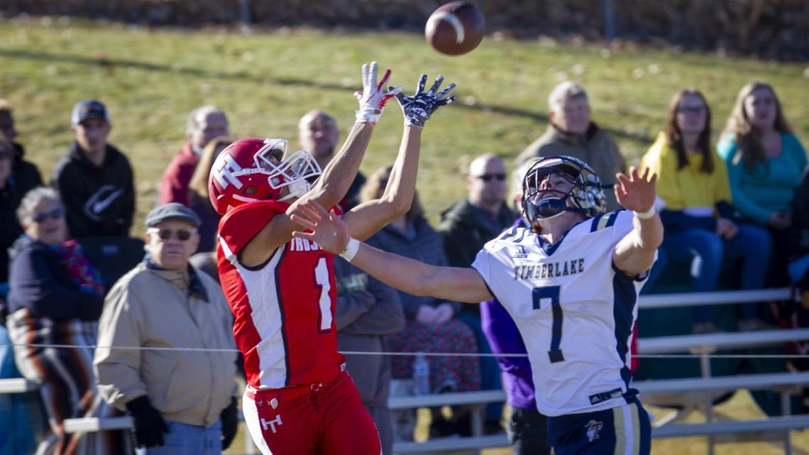 Homedale’s Caleb Smith hauls in a fourth-down pass under pressure from Timberlake’s Joey Follini last week in the 3A state semifinals.