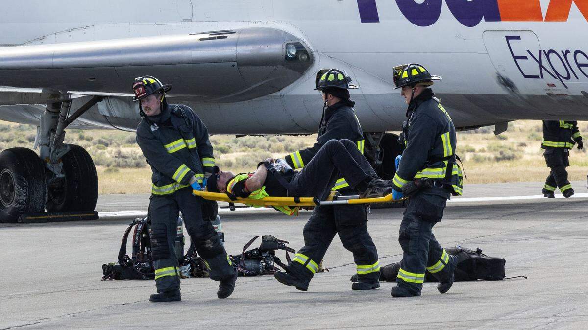 Boise firemen move a volunteer victim away from the site of a mock emergency during the Boise Airport Triennial Exercise disaster drill on Third Runway, Thursday, Aug. 7, 2025.