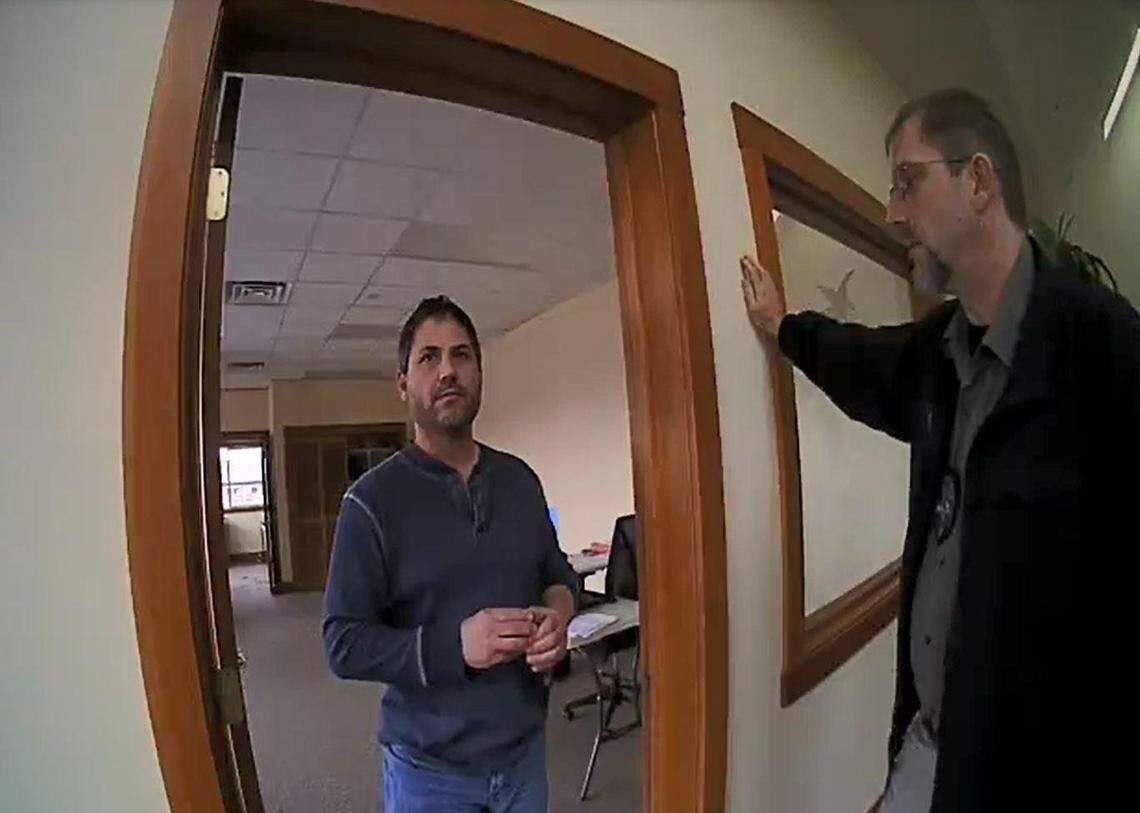 Scott Rhodes, left, speaks with Sandpoint police Officer Spencer Smith and Detective Mike Aerni, right, on Dec. 1, 2017. Police say Rhodes was captured on surveillance video the previous day distributing racist propaganda CDs at Sandpoint High School.