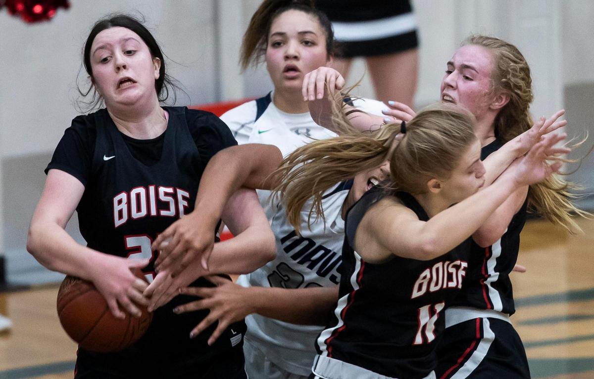 Boise’s Ashley Banks grabs a rebound in a crowded key in the 5A District Three championship last season.