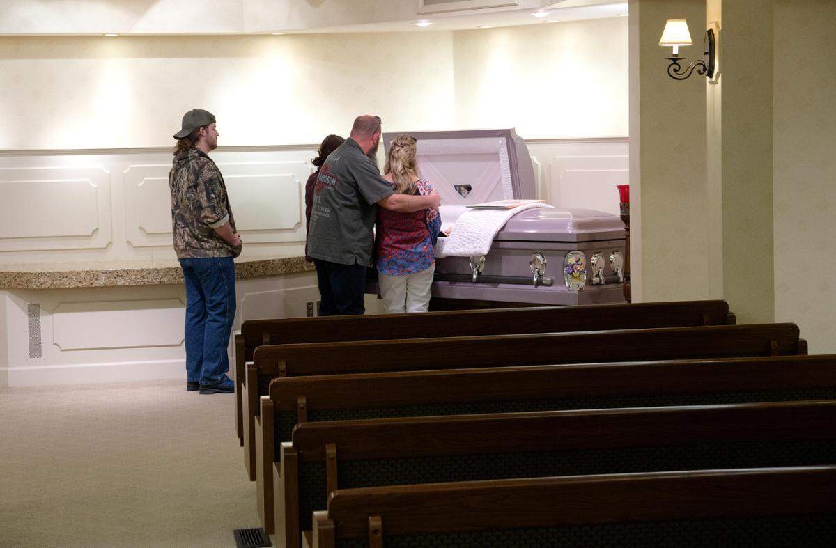 Michelle Lampert is embraced by her husband, Dino Lampert, during a viewing for her mother LaVonne Young in an empty chapel at Yates Funeral Home in Coeur d’Alene.