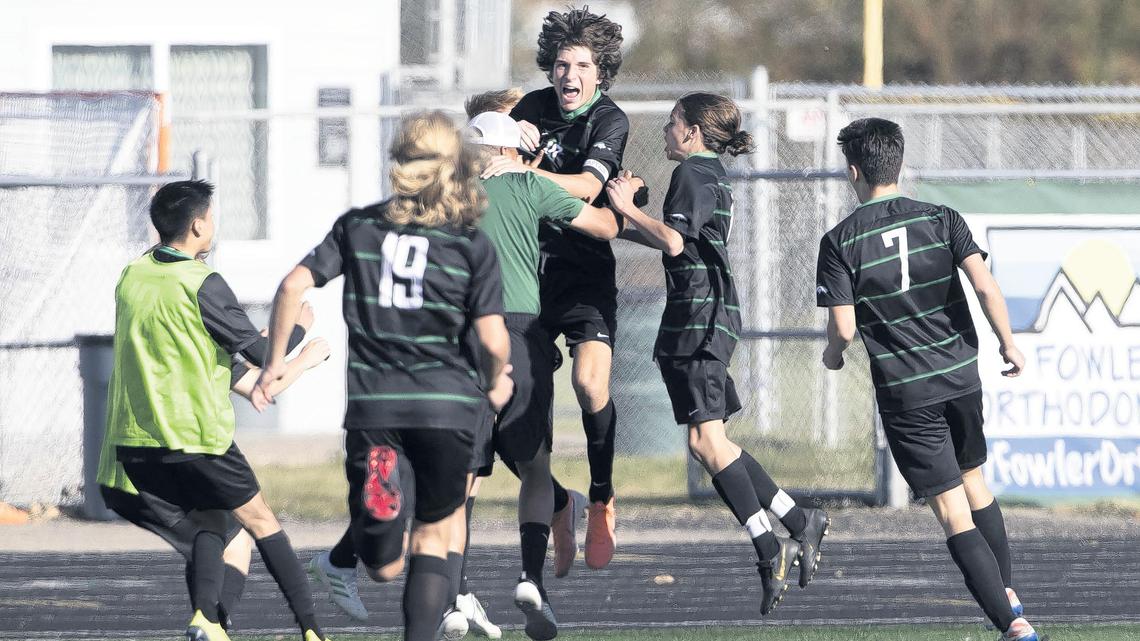 Eagle teammates rush senior Truman Hoggan after he scores the game-winning goal against Mountain View in double overtime Thursday at Eagle High. The Mustangs’ 1-0 win advances them into the semifinals of the 5A boys soccer state tournament.