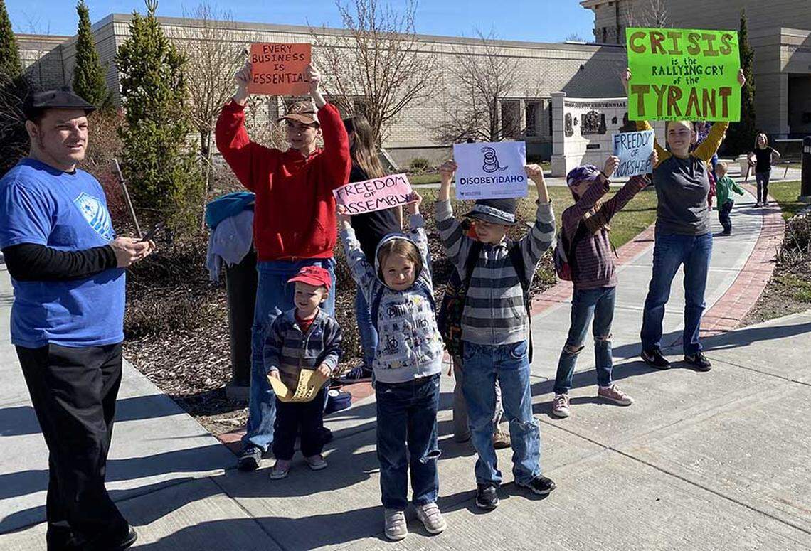 A family gathers in front of the Madison County Courthouse in Rexburg, Idaho, for the All Jobs Are Essential rally on Saturday, April 25. Protesters called on Gov. Brad Little to rescind his stay-home order for Idaho during the coronavirus pandemic.