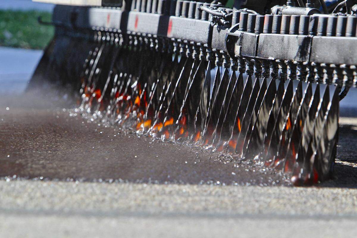 An Ada County Highway Department oil distributor applies a polymer-infused oil to South 12th Street.