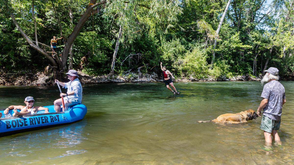 Kids use a swing tied to a tree to jump in the Boise River on Wednesday afternoon, July 20, 2023, when temperatures were in the mid-90s.