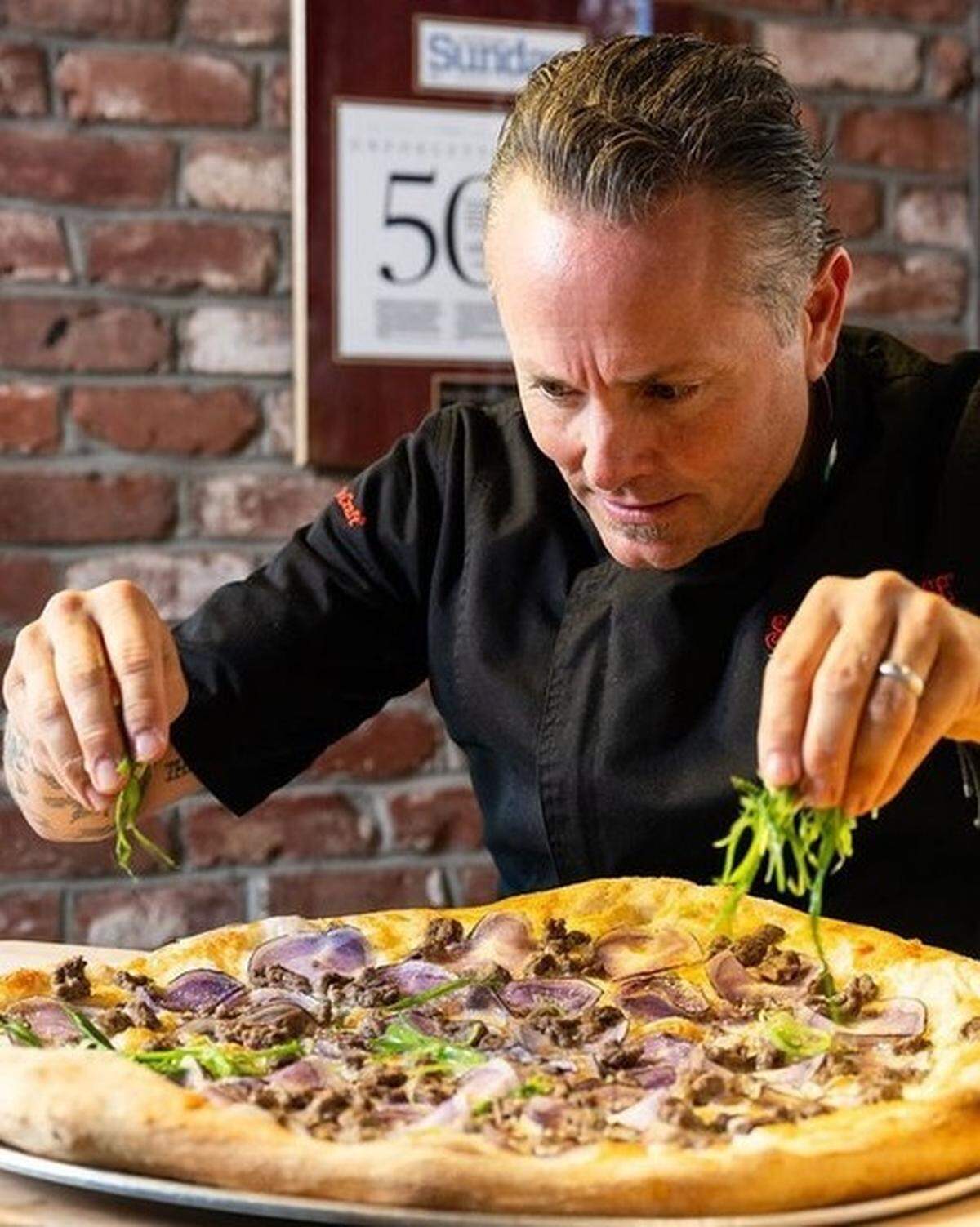 Slice House founder Tony Gemignani puts the finishing touches on a New York-style Big Papa.