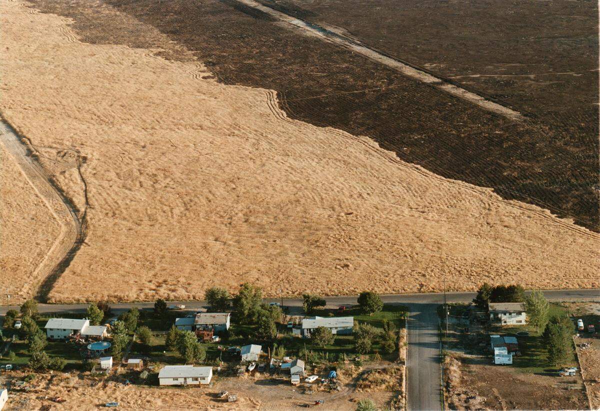 This file photo shows how close the Point Fire got to houses in July 1995. What started as a 120-acre fire that was mostly put out turned into a raging fire that killed two Kuna firefighters and eventually burned 11,000 acres over two days.