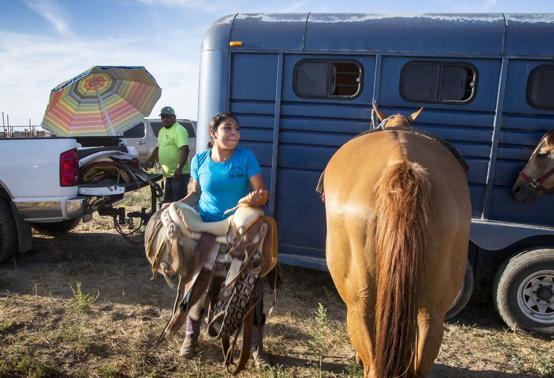 Nayeli Flores, 18, hoists a saddle onto her horse as the escaramuza team readies for practice northwest of Caldwell.