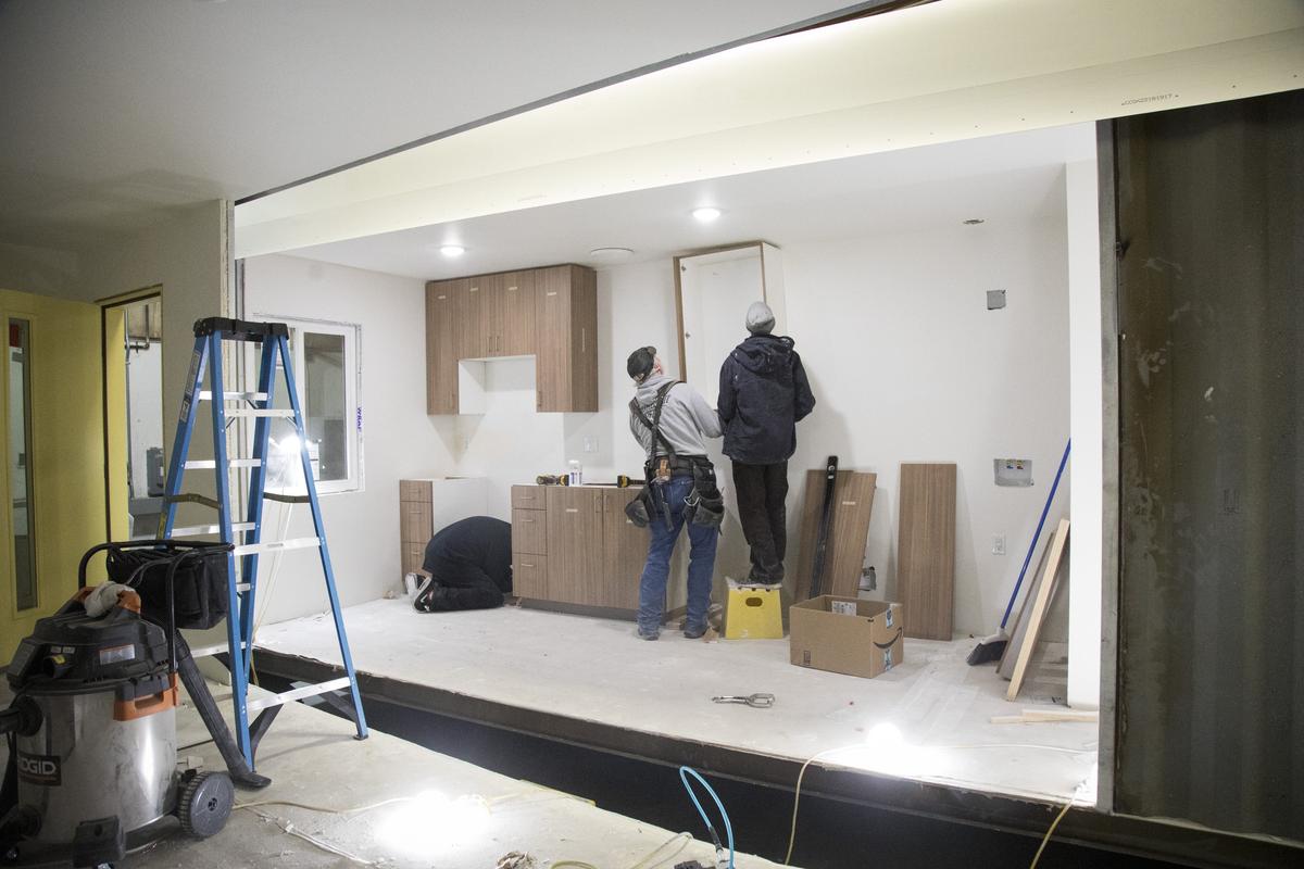 In the final stages of production, Kevin O’Brien, left, and Keegan Bradley install cabinets in the kitchen of a container home at IndieDwell's Caldwell factory.