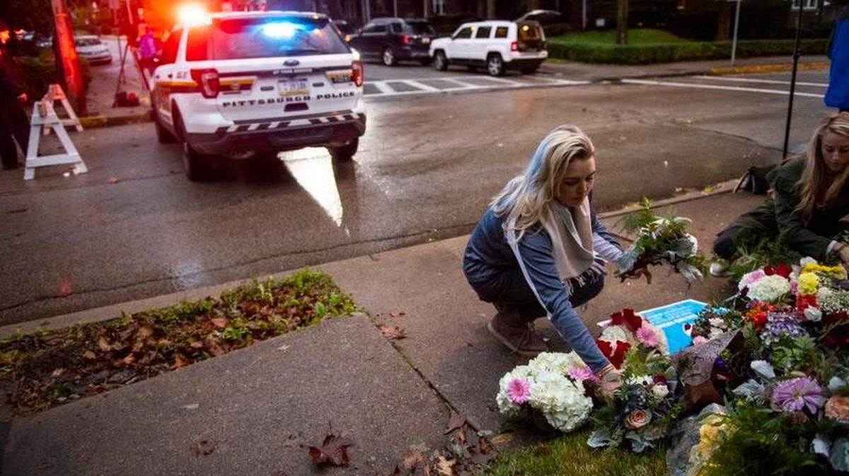 Adrienne Wager, left, and Shannon Haldeman place flowers near the Tree of Life Congregation, a day after 11 people died at the synagogue during a shooting rampage, in Pittsburgh, Oct. 28, 2018. Authorities on Sunday identified the 11 victims of the shooting in which a man armed with an AR-15-style assault rifle and three handguns shot into a morning worship service in the deadliest attack against the Jewish community in the United States in decades.