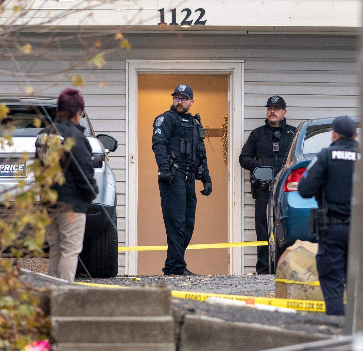 Police officers investigate a homicide at a home south of the University of Idaho campus on Sunday.